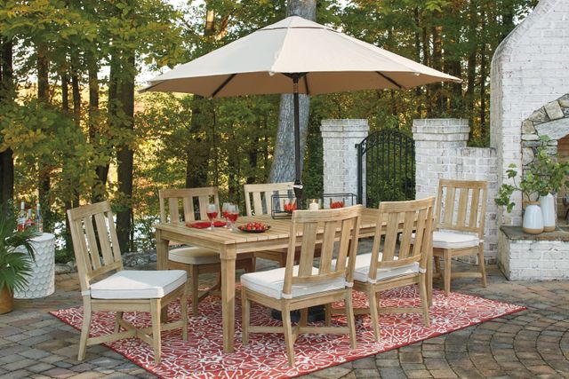 View of a modern outdoor patio dining table on an outdoor patio, with an unbrella open and wine on the table