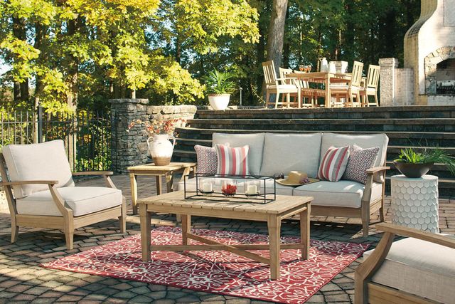 Front view of a modern outdoor patio with a conversation set and dining table set in the background