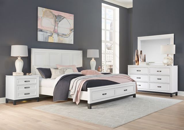 front view of a modern bedroom with grey walls, light wood floors, and a white bedroom set which includes a bed, two nightstands, and a dresser 