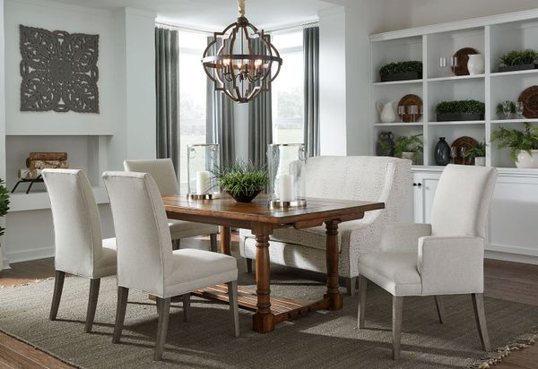 An elegant dark wood dining table and cream upholstered chairs in a well-lit dining area.