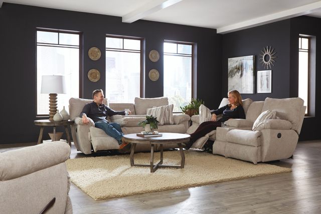 front view of a modern living room with two beige catnapper reclining sofas with cupholders and consoles