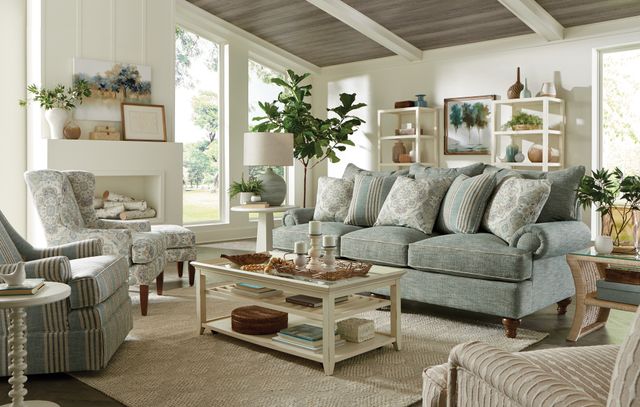 front view of a light blue sofa in a modern farmhouse style living room with white walls and plants and various white decor around