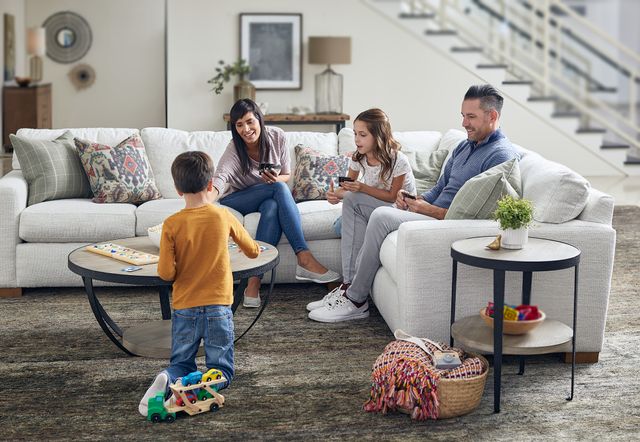 front view of a family playing cards in a flexsteel sectional in amodern living room
