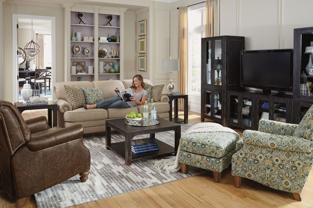 front view of a woman relaxing on a flexsteel sofa in amodern living room