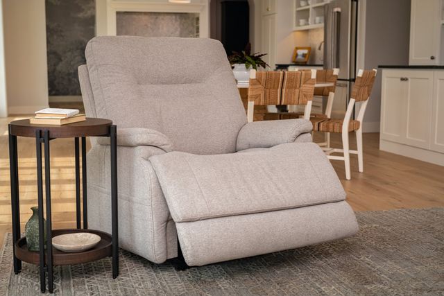 front view of a modern living room with a large fabric flexsteel recliner, slightly reclined out, with a side table next to it