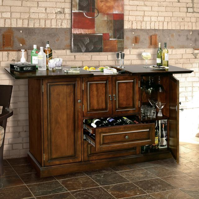 front view of wooden home bar in a rustic home, with various drinks, glassware, and garnishes on top