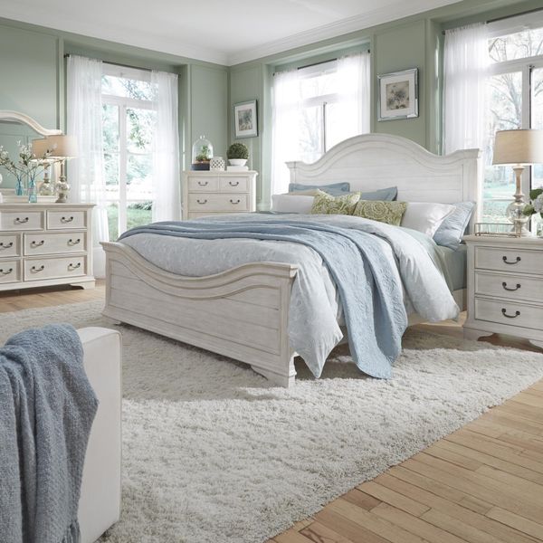 front view of a large bedroom with light green walls and white liberty bedroom furniture including a bed, nightstand, chest, and dresser 
