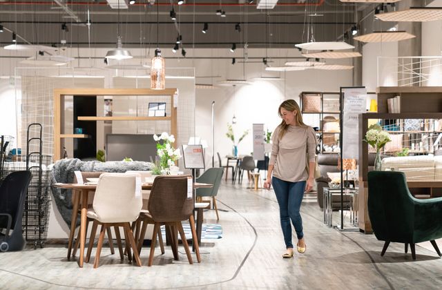 front view of a woman walking through a furniture store
