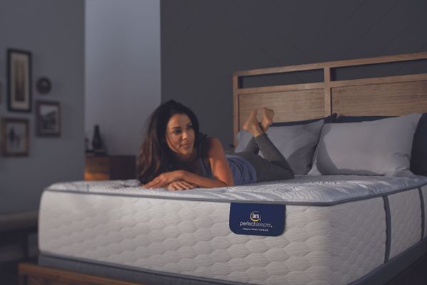 A woman lies on top of her Serta Perfect Sleeper mattress