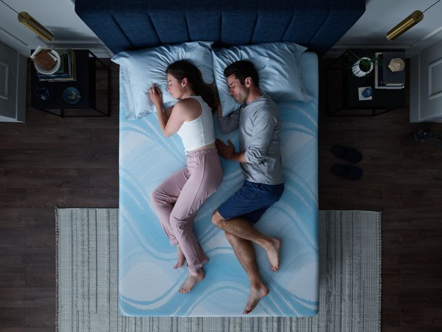 Top view of a man and woman comfortably sleeping on their sides in a Tempur-Pedic mattress