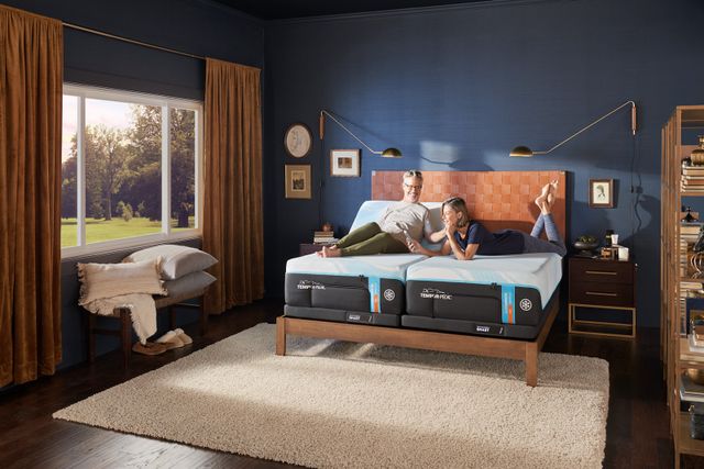 frront view of a couple laying on a tempurpedic luxebreeze split mattress in a modern bedroom