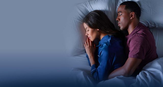 front view of a man and woman sleeping on their side on a tempur-pedic mattress