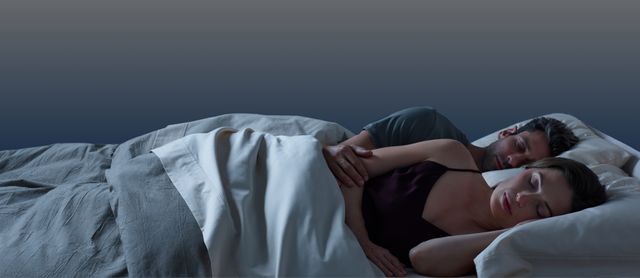 front view of a couple laying on their sides on a tempur pedic mattress