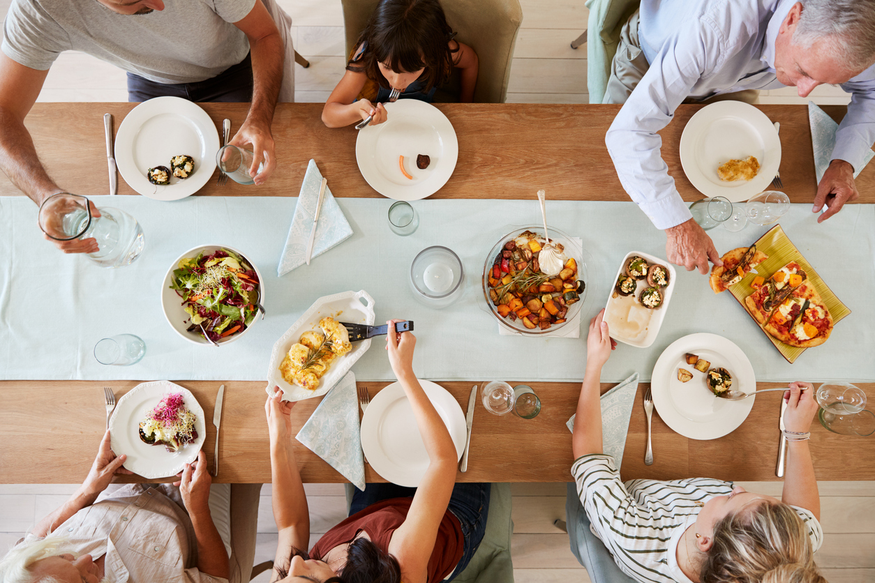 A shot from above of a family gathered around a dining table