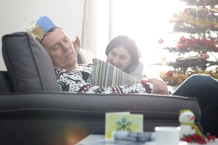 Dad naps at Christmas and is pestered by young family member