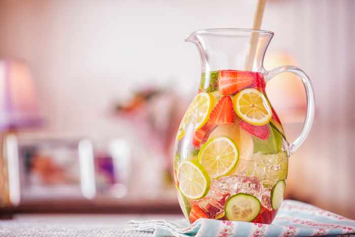 A pitcher full of water and fruit slices.