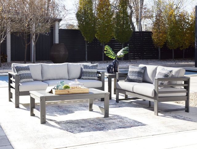 front view of a plastic outdoor sofa and matching coffee table and chair with a pool in the background