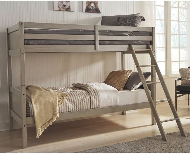 front left standing view of a beige twin over twin bunk bed in a beige colored kids room with bear portraits on the wall behind it