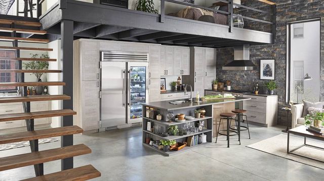 front view of a modern contemporary kitchen with a column refrigerator and freezer behind an island