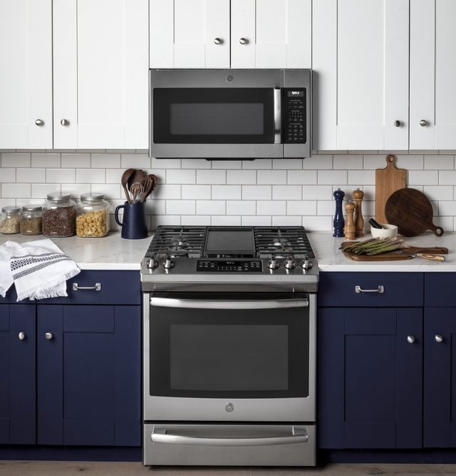 stainless steel oven/range and over the range microwave in a blue kitchen