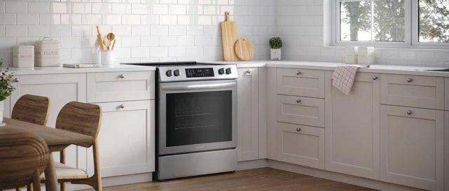 view of a kitchen with white cabinets and a white tile backsplash with a frigidaire electric range in the center