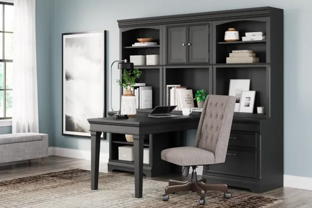 front view of a transitional style office with a large black desk and upholstered office chair