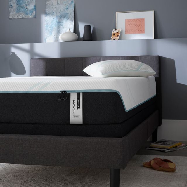closer view of a tempur pedic hybrid mattress on a black bed frame in a modern bedroom