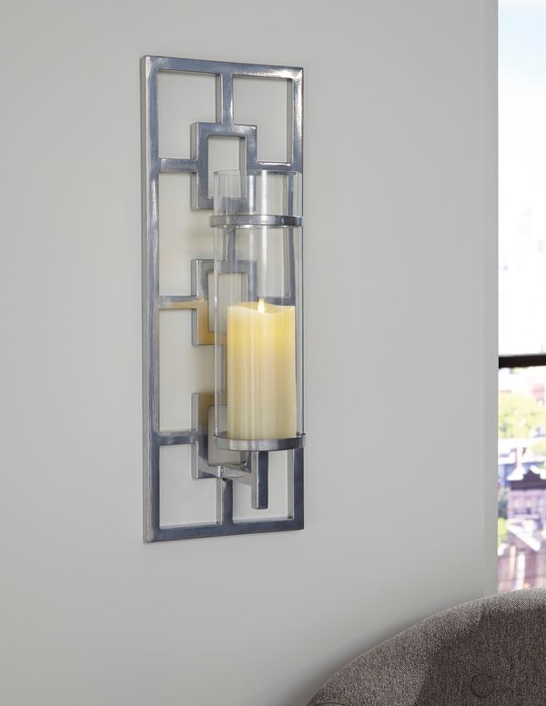 close view of a metal wall sconce with a candle on a white wall