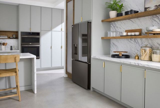 right angled view of a black stainless steel smart refrigerator built into white ceiling cabients