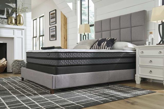 side view of a hybrid mattress from a box on a grey bed frame in a modern farmhouse style bedroom