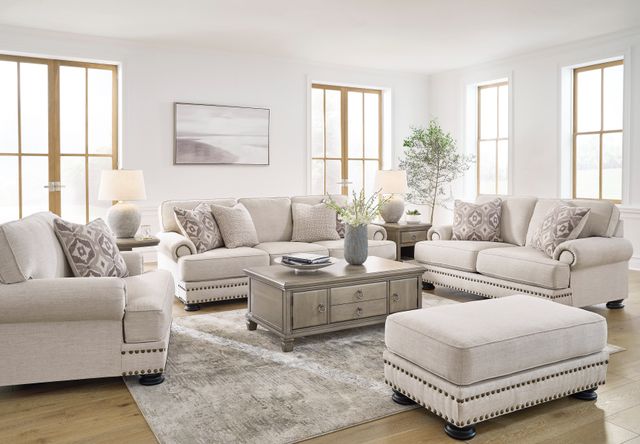 front view of a transitional living room with cream sofas, and matching ottoman and coffee table