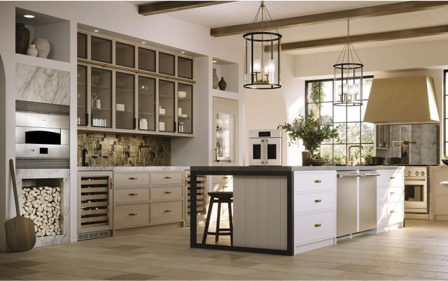 view of a modern beige kitchen full of appliances with an island and a french door wall oven