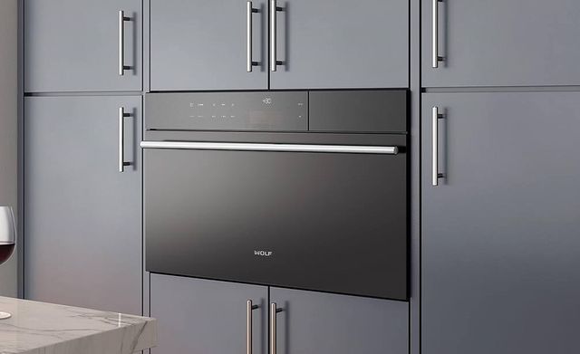 front view of a black wolf oven in light gray cabinetry