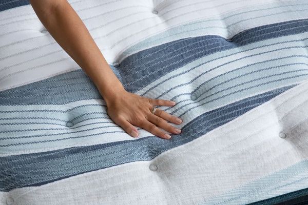 Woman Examining Beautyrest Harmony Mattress Thickness