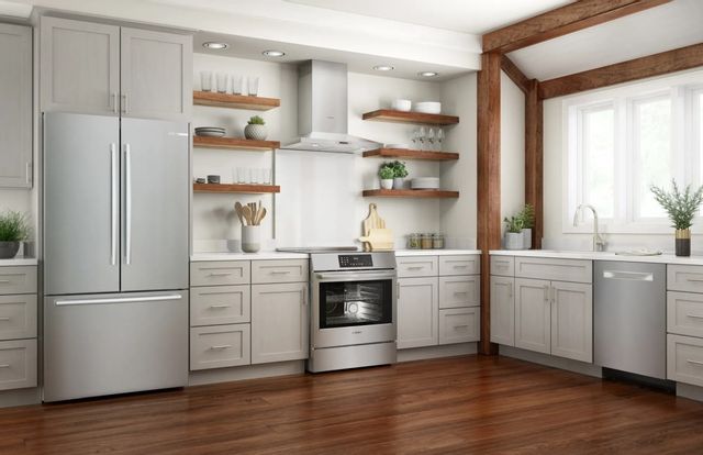 front view of a modern kitchen with stainless steel appliances, including an induction range, and white cabinets