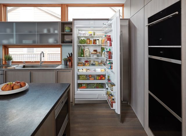front view of a modern kitchen with an opened, fully-stocked, column refrigerator