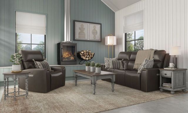 how-to-choose-a-sofa front view of a modern farmhouse living room with light blue panel walls, and a transitional brown leather sofa and matching recliner, with rustic carved wood coffee and side tables
