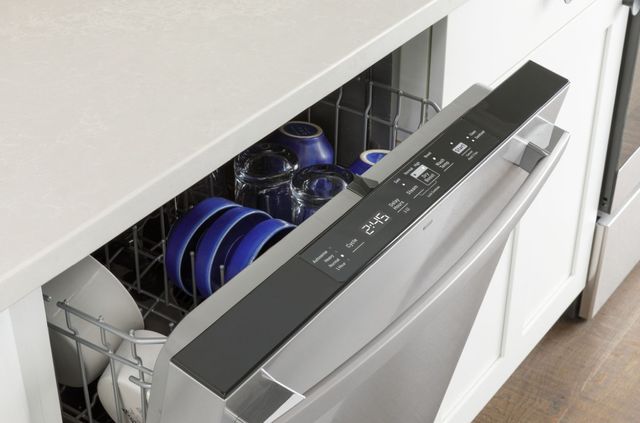 top angled view of a slightly opened dishwasher showing blue dishes inside