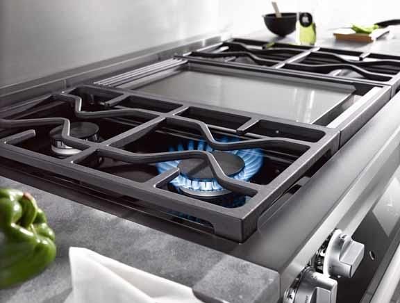 closeup side view of a miele gas cooktop, with the closest flame on