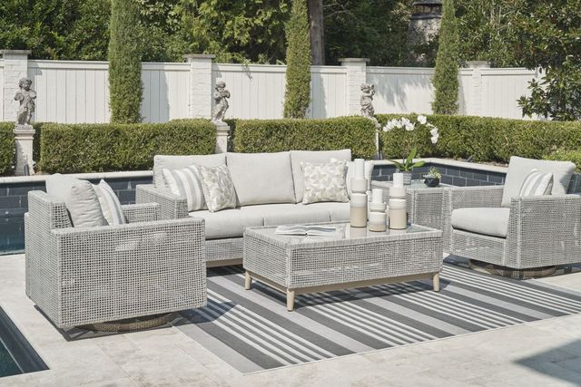 front view of a modern back patio and pool with a light grey outdoor sofa, matching chairs and coffee table in the front