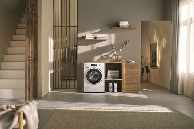 front view of a miele heat pump dryer in a modern beige laundry room