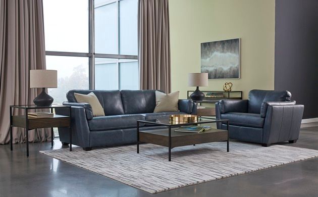 front view of a modern living room with navy blue leather sofa and chair with contemporary coffee and side tables