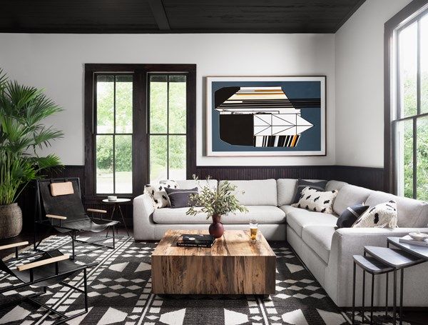 side view of a modern living room with grey walls and sofa, and a Four Hands Furniture wood coffee table
