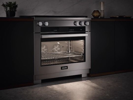 low-exposure image of a miele range with the inside oven light on