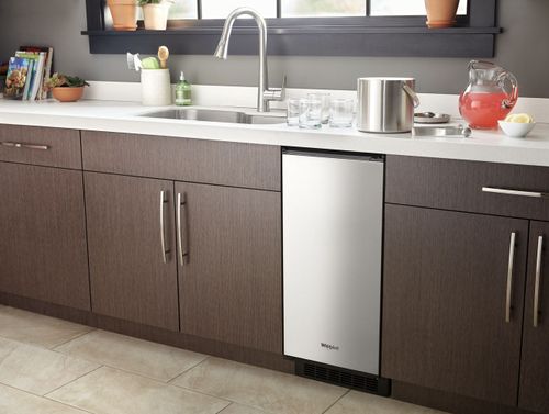 front view of a kitchen sink with an ice maker in the cabinets below