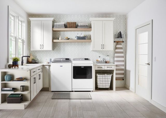front view of a modern laundry room with a top load washer and front load dryer