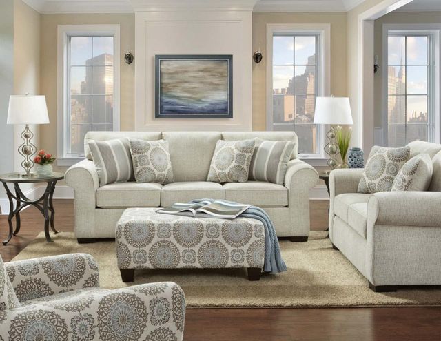 front view of a modern living room with a beige sofa and matching loveseat, accent chair, and ottoman