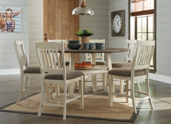 front view of a round beige dining table and chairs in a farmhouse dining room