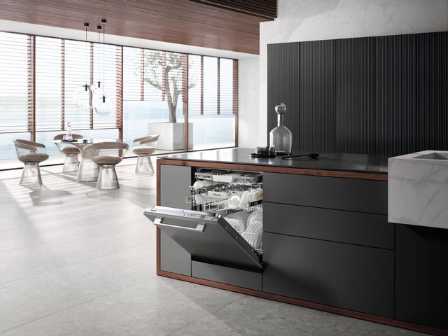 angled view of a modern luxury kitchen with a slightly opened miele panel ready dishwasher in the island