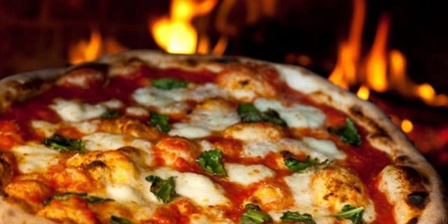closeup view of a neapolitan pizza in an outdoor pizza oven 